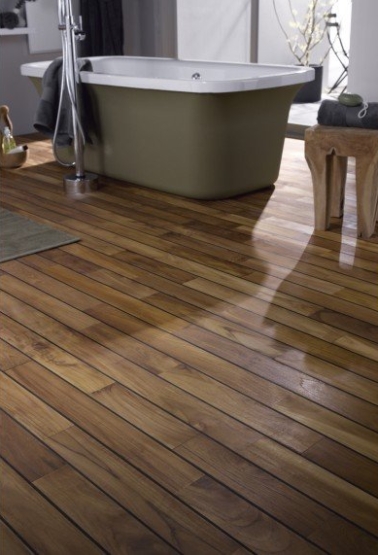 La bonne idée déco de cette salle de bain, c’est le camaïeu de la peinture gris souris et de la baignoire îlot kaki qui trône sur un parquet en bois exotique huilé.