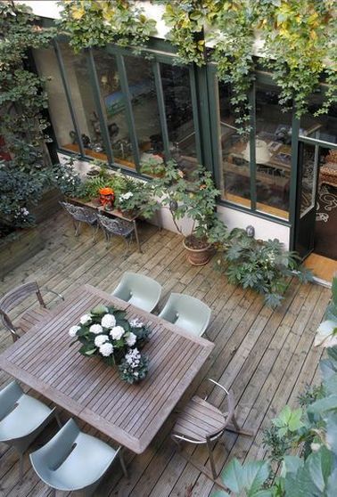 Une terrasse bohème aménagée avec des plantes en pots