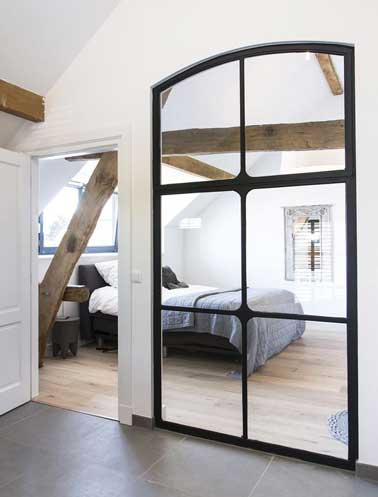 Une chambre parentale qui double sa surface grâce à une verrière intérieure composée de miroir fixée au mur le plus long de la chambre