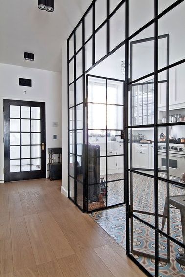 Une verrière intérieure de cuisine qui rappelle le décor de la porte principale Une verrière intérieure dans la cuisine peut être composée de différentes vitres rectangulaires ou carrées comme ici. Ajoutez aussi un sous-bassement pour une personnalisation totale !
