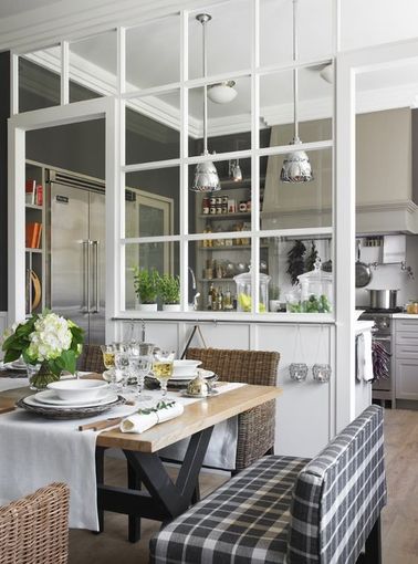 Une verrière intérieure blanche qui sépare la cuisine de la table à dîner Cette verrière d’intérieur est assez présente dans ce coin repas mais la légèreté des vitres carrées n’alourdit pas la décoration. On peut toujours y garder un œil sur la cuisine !
