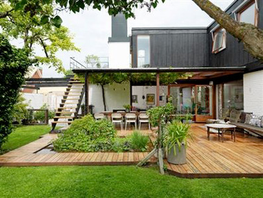 Aménager une jolie terrasse en bois avec un parterre de verdure c'est une bonne idée déco à l'extérieur. Une terrasse qui ne manque pas de charme et d'allure 