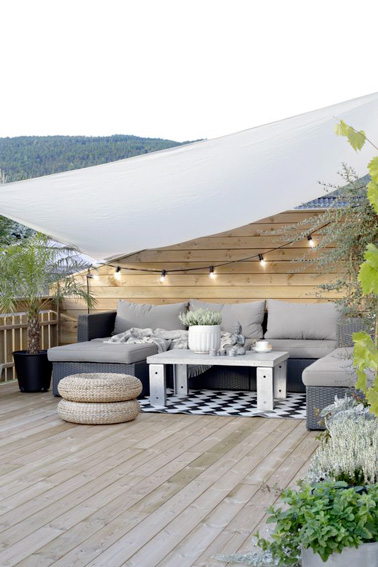 Le voile d'ombrage c'est l'accessoire incontournable de l'été pour se prélasser à l'extérieur. Aménagée sous un voilage blanc, cette terrasse se fait déco et accueillante 