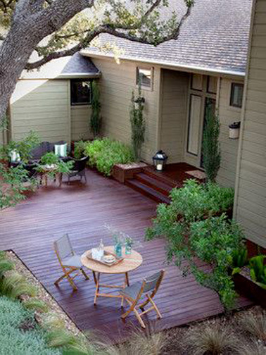 Pour un petit coin intime afin d'installer sa terrasse, l'arrière de la maison est l'endroit idéale ! Une jolie terrasse en bois pour prendre les repas à l'extérieur l'été 