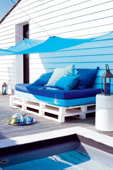 Facile à réaliser avec deux palettes peintes en blanc, ce canapé en palette s'aménage parfaitement au bord de la piscine, avec sa voile d'ombrage et ses nuances de bleu