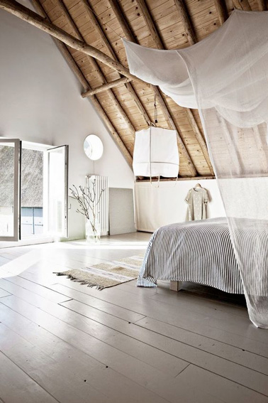 Parquet, couleurs claires, descente de lit, lanterne et ciel de lit s'associent pour une déco ultra zen dans la chambre parentale et son petit balcon ouvert sur le jardin 