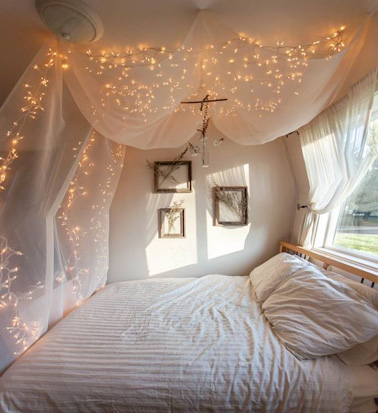 Voilà une déco féérique dans la chambre ! Le ciel de lit s'illumine d'étoiles grâces à des guirlandes lumineuses. Une bonne idée déco pour une ambiance scintillante assurée