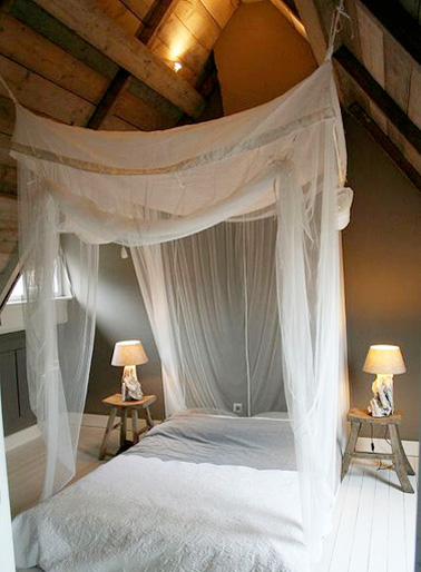 Voilà une chambre sous combles qui ne manque pas de romantisme avec un beau ciel de lit suspendu et une ribambelle de lumières tamisés pour une déco ultra relaxante 