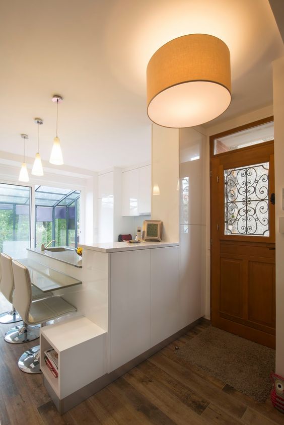 Délimitée par un bar très pratique, cette cuisine ouverte sur le hall d'entrée respire la modernité. Une cuisine blanche lumineuse ne manquant pas de style pour une déco tendance 