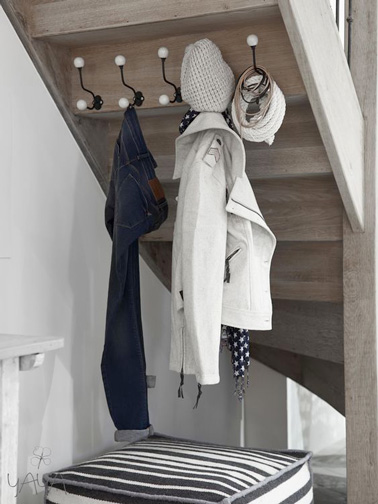 Pour optimiser l'espace dans l'entrée de la maison, installer un porte manteau pour accrocher vestes et écharpes sous les escaliers, c'est une bonne astuce déco ! 