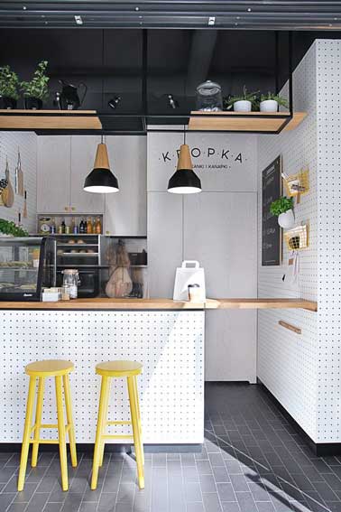Pour agrandir de manière déco une petite cuisine ouverte l'astuce est d'aménager un îlot cental en retour des meubles en L qui double les rangement et sert aussi de coin repas 