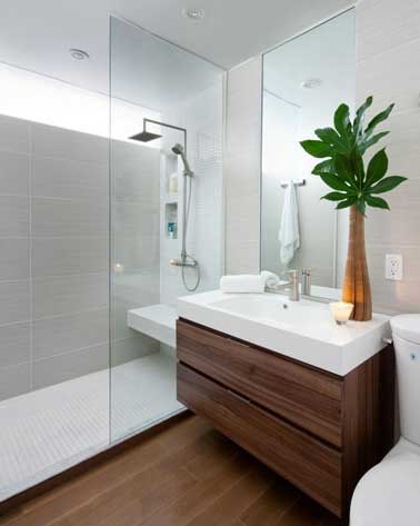 Dans une petite salle de bain, à la fois pratiques et accessoires de déco, un grand miroir et une paroi douche en verre pour douche italienne agrandissent l’espace