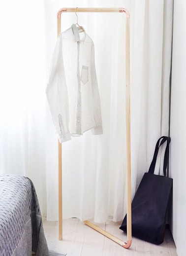 Pour obtenir un petit espace de penderie supplémentaire dans la chambre, voici un portant à vêtements très facile à réaliser avec des barres en bois et des coudes en cuivre