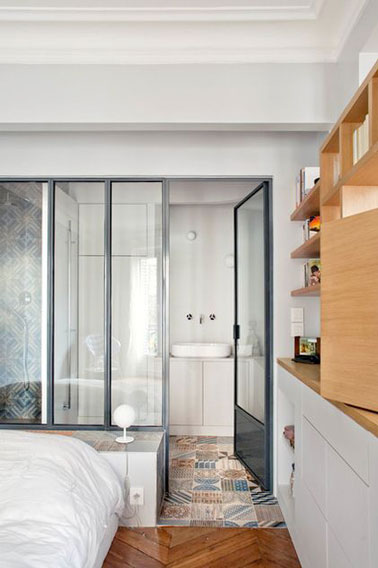 Place à la luminosité dans cette suite parentale où la lumière est au rendez-vous dans la salle de bain grâce à l'aménagement d'une verrière intérieure ultra tendance