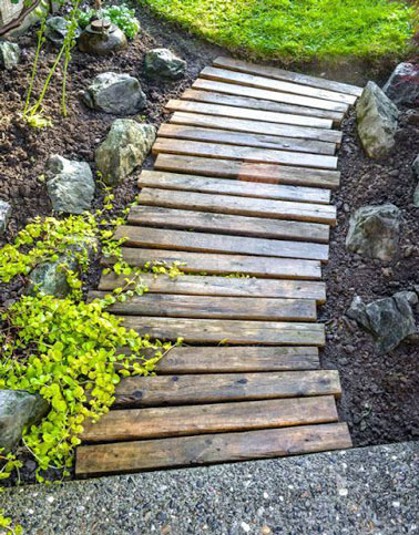 L'aménagement d'une allée de jardin fait avec des planches de palette en bois, pour apporter une touche plus esthétique et harmonieuse à une déco extérieure.