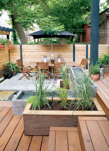 Une belle terrasse en bois à deux niveaux protégée du vis à vis grâce à un brise-vue en pin. Un salon de jardin en teck pour accueillir vos convives et voilà un aménagement top !