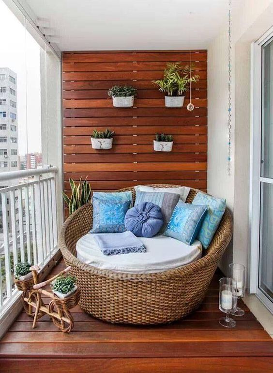 Le bleu et le bois font bon ménage sur ce balcon ! Le magnifique fauteuil en osier accueille des coussins bleu pastel qui donnent une touche de couleur à la déco