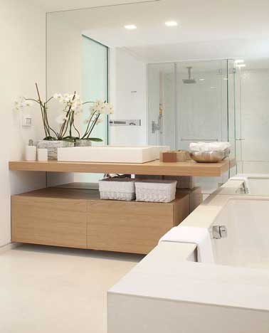Une salle de bain qui rassemble tous les éléments pour créer son ambiance zen : Peinture couleur lin, du bois avec le meuble vasque suspendu et baignoire design aux lignes épurées.