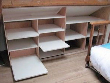 Les combles, un problème pour les dressings sous pente à cause de leur profondeur. Remédier à cela avec des rails ou des plaques coulissants pour prendre facilement les affaires.