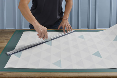 Pour la première étape, concevez et découpez des formes géométriques de différentes tailles dans les papiers peints que vous avez choisi à l'aide d'un cutter.