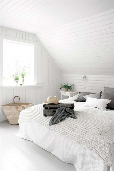 Total look blanc dans la chambre avec du lambris PVC sur les murs et le plafond, marié à un parquet blanc, le tout souligné par des touches de beige et de gris 