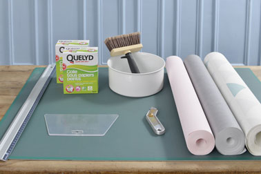 Pour réaliser une déco murale ultra tendance aux formes géométriques, il vous suffit d'utiliser différents papiers peints colorés et de la colle à papier peint 