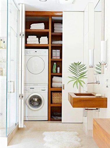 Aménager une buanderie dans le placard derrière une porte coulissante, voilà une solution rangement astucieuse et pratique dans cette petite salle de bain zen 