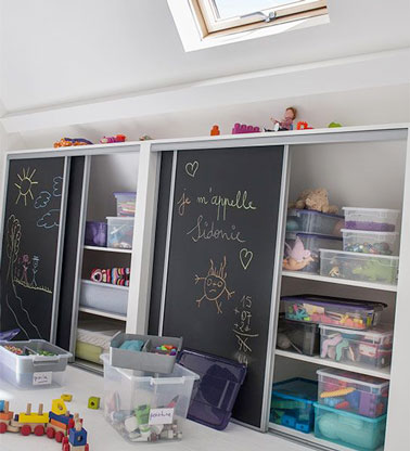 Pour donner envie aux enfants de ranger les jouets à la fin de la journée, on peint les portes du placards à la peinture tableau noir ! Une bonne idée ludique pour s'exprimer 