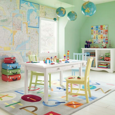 Voilà une déco ludique pour jouer et apprendre en même temps grâce à du papier peint réalisé avec des cartes du monde, un tapis alphabet et des suspensions en globe terrestre 