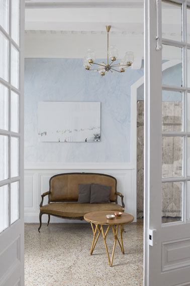 En voilà une entrée coquette ! Du stuc bleu vénitien appliqué sur les murs, un lustre et un canapé antique pour une déco qui ne manque pas de classe et d'allure 