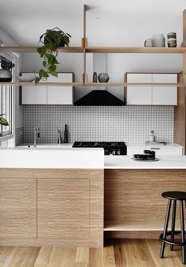 La crédence en carrelage adhésif composée de petits carrés blancs se marie parfaitement à la déco de cette kitchenette blanche et bois ultra accueillante 