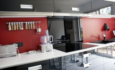 Comme dans cette cuisine noire et rouge design, la peinture V33 devient votre meilleure alliée pour repeindre votre crédence en carrelage vieillotte et passée de mode