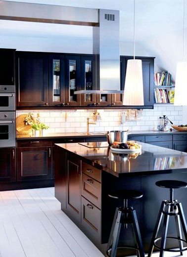 Un mélange des styles très réussi dans cette cuisine noire design aménagée avec un îlot central contrastant avec une crédence en carrelage métro blanc ultra stylé
