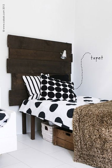 La tête de lit réalisée en assemblant des planches de bois vernies donne du caractère à cette chambre blanche ! Une idée déco pas chère à reproduire facilement