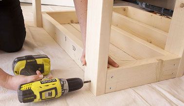 Alt : Avec des tasseaux de bois de 4x6 cm, fixer les pieds de la desserte à chaque extrémité d'un des cadres et ensuite, le retourner pour fixer l'autre cadre aux pieds.