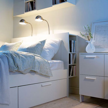 Rangement optimal dans cette petite chambre blanche ultra design ! Un lit avec tiroirs et niches de rangements intégrés dans la tête de lit pour une chambre bien ordonnée