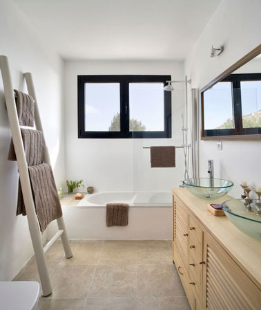 Les couleurs naturelles font la déco dans cette petite salle de bain meublé avec le strict minimum, une baignoire, un meuble de rangement et une échelle, pour un espace maximisé !