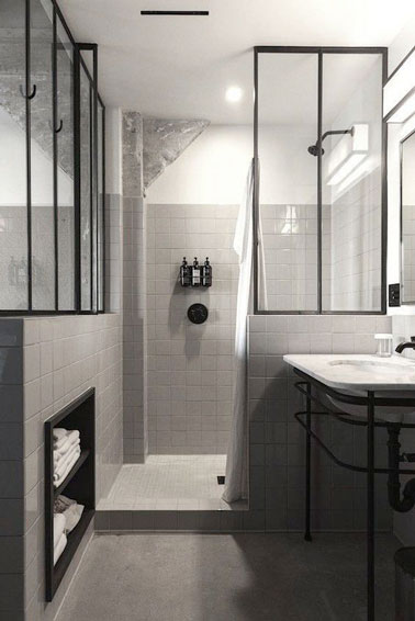 La verrière intérieure donne du style à la déco de cette salle de bain aménagée avec une niche de rangement et une douche italienne pour une optimisation totale de l'espace 