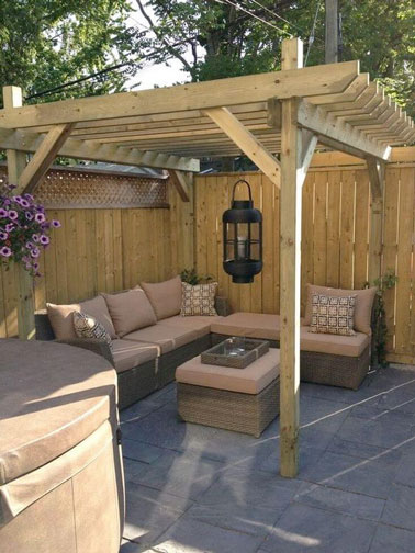 Sous la pergola en bois, le salon de jardin trouve naturellement sa place sur cette petite terrasse abritée hyper conviviale et déco protégée du vis à vis ! 