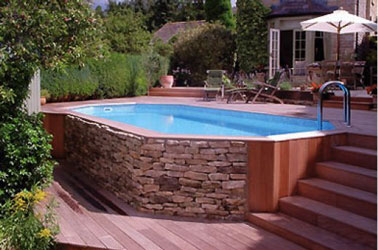 Aménagée en contrebas de la terrasse en bois, cette charmante piscine hors sol sertie de pierre et de bois au style authentique sublimera votre déco extérieure 