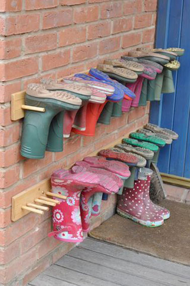 Spécial extérieur, ce rangement pour chaussures est ultra facile à réaliser avec des baguettes rondes et des planches de bois fixées au mur devant la maison 