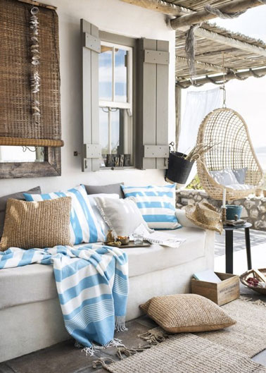 Ambiance bord de mer sur la terrasse cosy aménagée sous la pergola devant la maison qui promet des moments de tranquillité absolue sur le canapé de jardin ! 