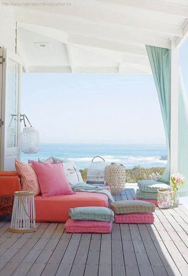 Rien de plus cosy qu'un petit canapé décoré de coussins colorés sous le porche de la maison ! Un espace extérieur de détente avec vue mer ultra craquant et déco 