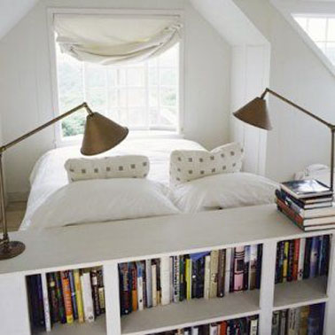 Une tête de lit aménagée en bibliothèque, une idée astucieuse et originale pour obtenir des rangements supplémentaires dans cette petite chambre blanche 