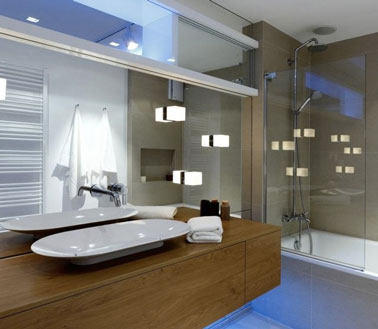 La déco ultra moderne de cette salle de bain est accentuée par des luminaires tendances ! Des cubes lumineux ont été fixés au miroir pour un effet original !