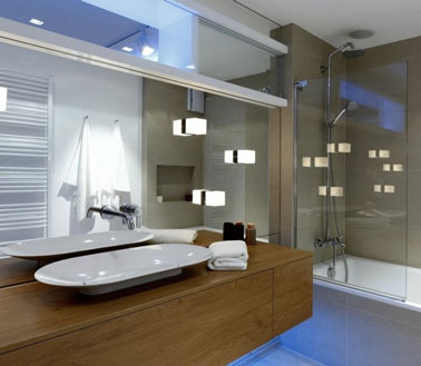 La déco ultra moderne de cette salle de bain est accentuée par des luminaires tendances ! Des cubes lumineux ont été fixés au miroir pour un effet original !