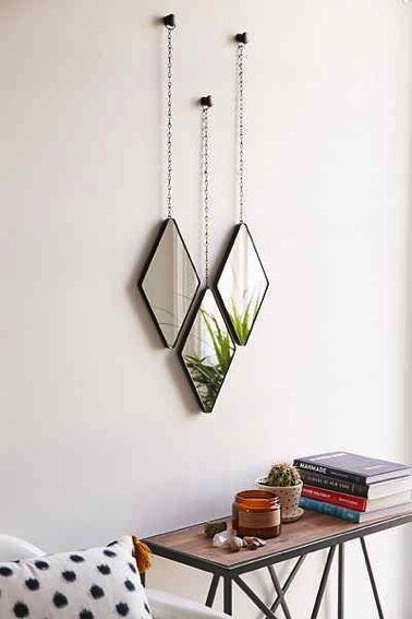 Une touche déco hyper charmante donnée par trois petits miroirs en forme de losanges suspendus à des chainettes apportent de l'originalité à la chambre ! 