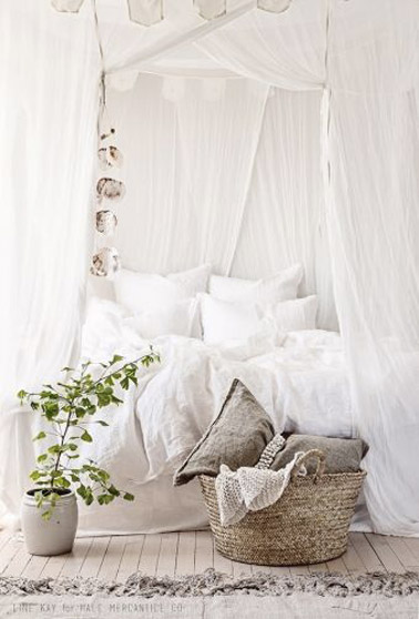 Cette chambre cosy blanche avec voilages, parquet blanchi et tapis beige s'approprie une atmosphère douce où les voilages font ciel de lit pour un cocon charmant 