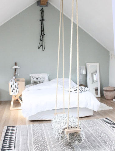 Ambiance de douceur dans cette chambre originale où une balançoire s'est invitée dans la déco avec un plafond blanc cassé, des murs gris perle et un parquet blanc 