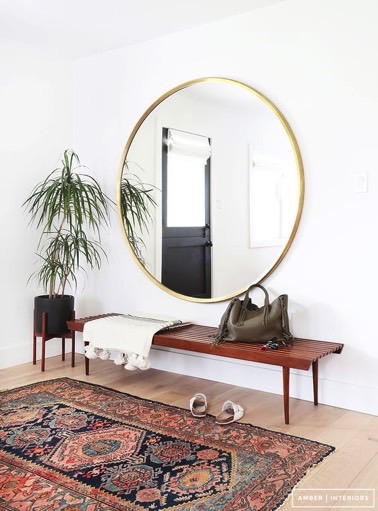 Voilà une idée à reprendre si votre hall d'entrée vous paraît trop petit ! Un grand miroir rond offrira un effet d'agrandissement à la pièce, hyper déco et futé !